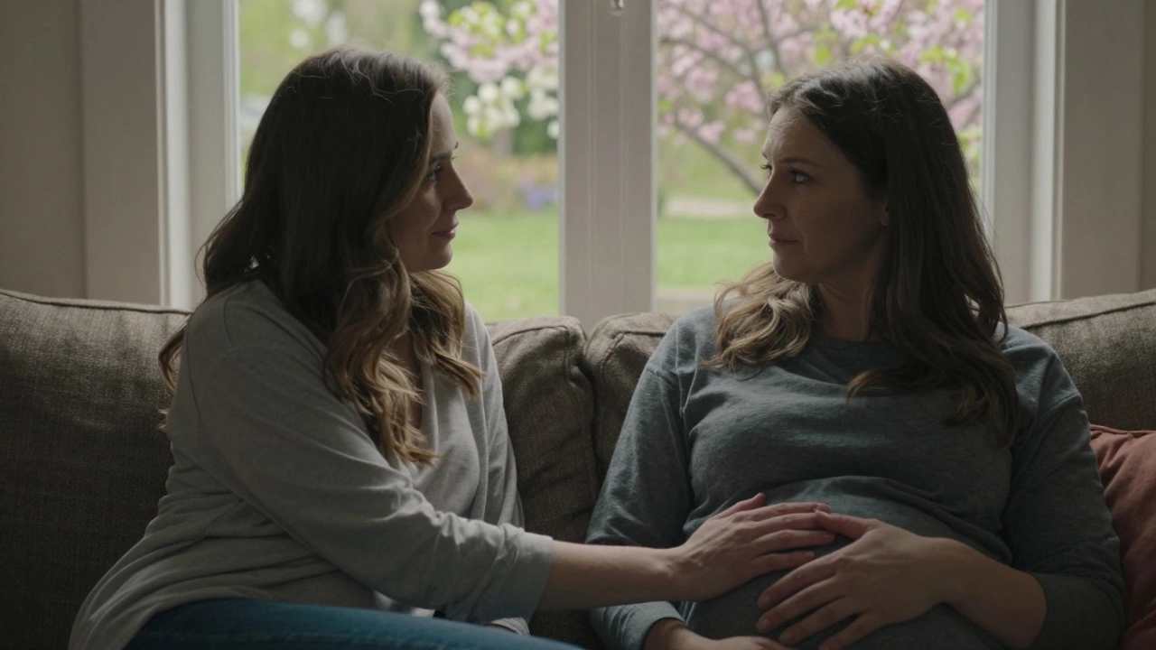 Žena a její partner sedí spolu na pohovce, on drží ruku na jejím břiše.